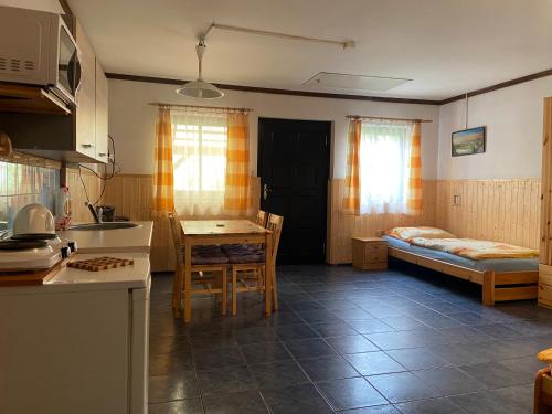 eine Küche mit einem Tisch und einem Bett in einem Zimmer in der Unterkunft Apartmán u Marušky in Chřibská
