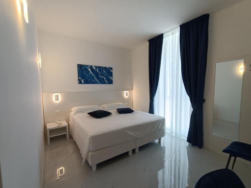 a bedroom with a white bed and a window at Hotel Smart Cruise in Civitavecchia