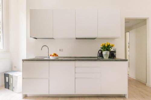 a white kitchen with white cabinets and a sink at Casa Cadrega in Milan