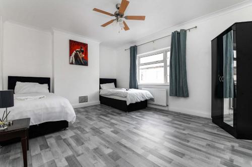 a bedroom with two beds and a ceiling fan at The White Rose Crown, Free Parking & Wifi, 8 beds in Colchester