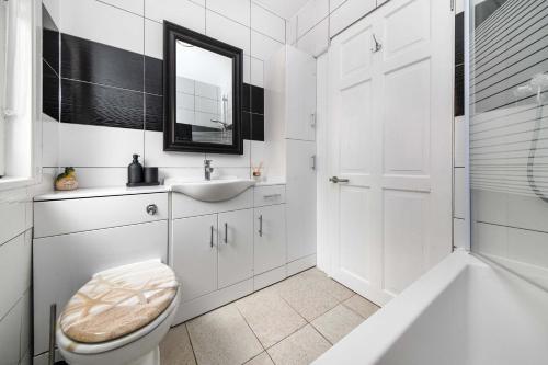 Un baño blanco con lavabo e inodoro. en The White Rose Crown, Free Parking & Wifi, 10beds, en Colchester