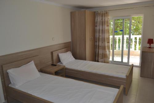 two beds in a room with a window at Hotel Victoria in Olympic Beach
