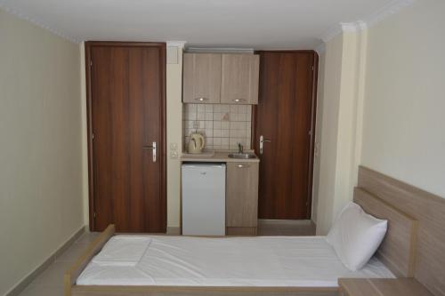a small bedroom with a bed and a kitchen at Hotel Victoria in Olympic Beach