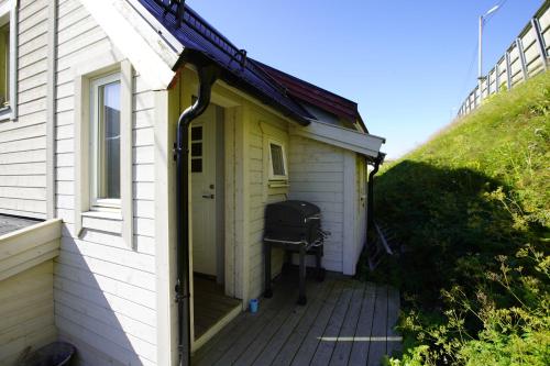 een kant van een huis met een grill op een veranda bij Cosy House Strangata in Måsøy