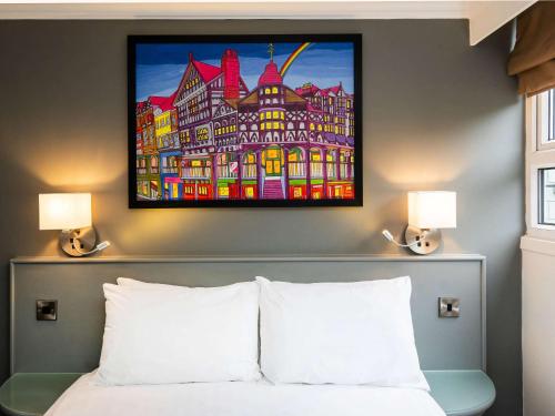 a bedroom with a painting above a bed at Mercure Chester Abbots Well Hotel in Chester