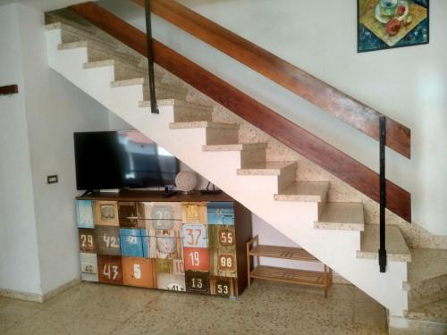 a living room with a staircase and a tv at Duplex Apartment in Edificio Altemar in Playa de las Americas