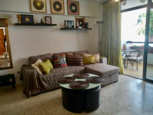 a living room with a couch and a table at Duplex Apartment in Edificio Altemar in Playa de las Americas