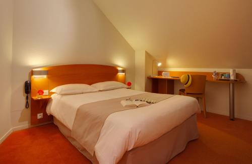 Un pat sau paturi într-o cameră la Kyriad Rennes Nord Hotel
