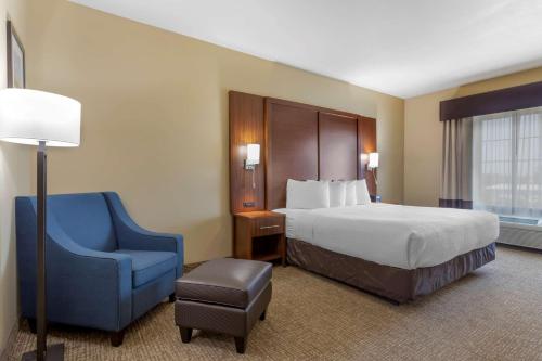 a hotel room with a bed and a blue chair at Best Western Texas City in Texas City