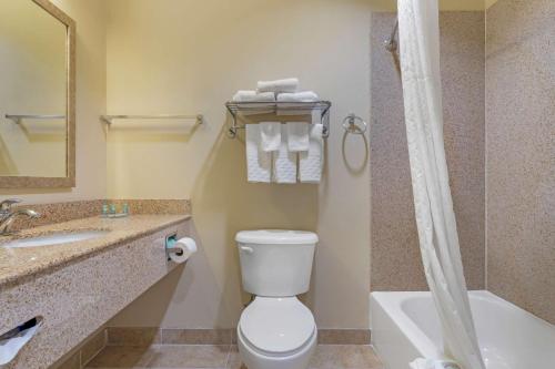 a bathroom with a toilet and a sink and a tub at Best Western Texas City in Texas City