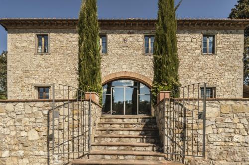a stone house with a staircase and two trees at Castello di Spaltenna Exclusive Resort & Spa in Gaiole in Chianti