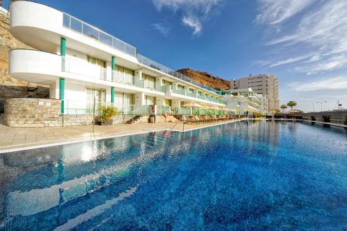 a large swimming pool in front of a building at Morasol Suites in Puerto Rico de Gran Canaria