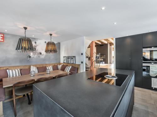une cuisine et un salon avec un comptoir noir dans l'établissement Chalet moderne avec jacuzzi et 5 chambres, proche télécabine et ski-bus, Méribel Le Raffort - FR-1-566-14, à Les Allues