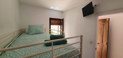 a bedroom with a bunk bed and a flat screen tv at Casa mediterránea Miami Playa in Miami Platja