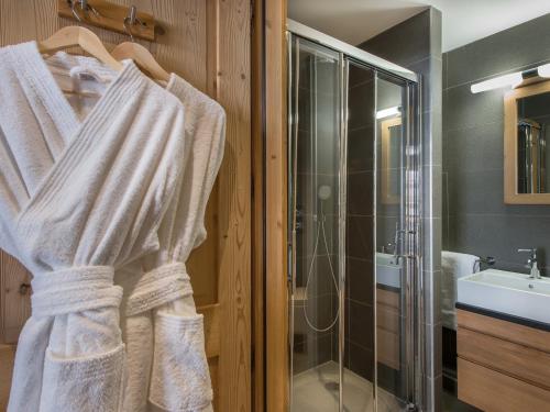 La salle de bains est pourvue d'une douche et d'une serviette blanche. dans l'établissement Appartement Duplex 8 pers. au Centre de Courchevel Moriond, à 150m des Pistes - FR-1-563-4, à Courchevel