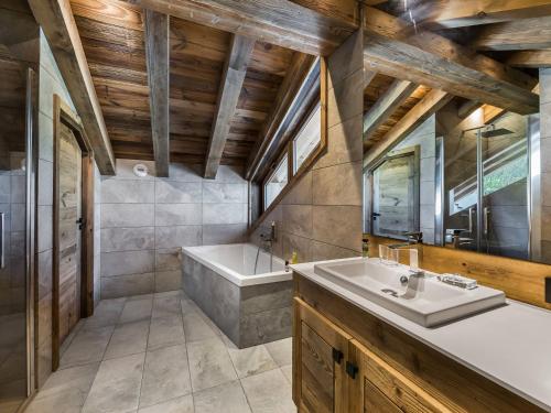 une salle de bain avec une baignoire et un lavabo dans l'établissement Duplex lumineux 5 chambres en-suite, sauna, proche pistes et commerces, Méribel Village - FR-1-566-10, à Les Allues