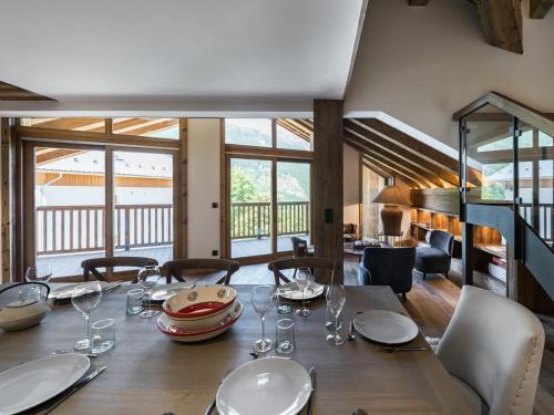 une salle à manger avec une table en bois et des verres à vin dans l'établissement Duplex lumineux 5 chambres en-suite, sauna, proche pistes et commerces, Méribel Village - FR-1-566-10, à Les Allues