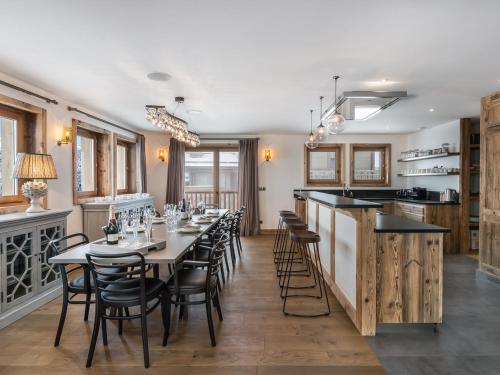 une salle à manger avec une longue table et des chaises dans l'établissement Chalet luxe avec sauna, cheminée et services inclus à Courchevel 1650 - FR-1-563-89, à Courchevel