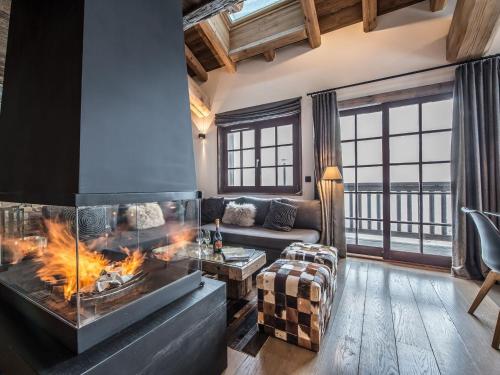 ein Wohnzimmer mit Kamin und Couch in der Unterkunft Chalet chaleureux familial avec spa, sauna et proche pistes à Méribel Village. - FR-1-566-24 in Les Allues