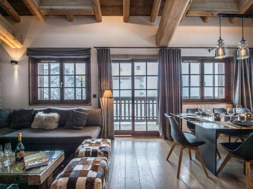 un salon avec un canapé et une table dans l'établissement Chalet chaleureux familial avec spa, sauna et proche pistes à Méribel Village. - FR-1-566-24, à Les Allues