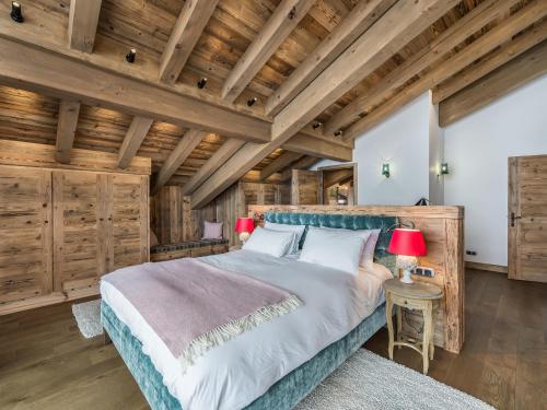 - une chambre avec un grand lit et des plafonds en bois dans l'établissement Chalet luxe avec sauna, cheminée et services inclus à Courchevel 1650 - FR-1-563-89, à Courchevel