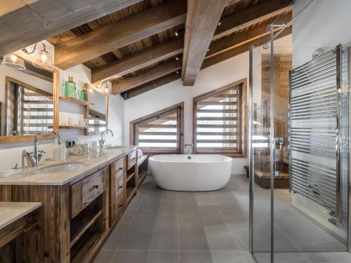 une grande salle de bain avec une baignoire et un lavabo dans l'établissement Chalet luxe avec sauna, cheminée et services inclus à Courchevel 1650 - FR-1-563-89, à Courchevel