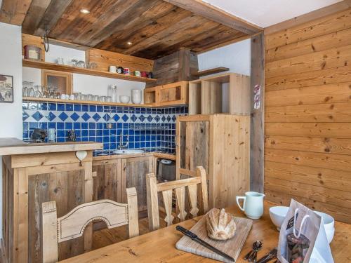 - une cuisine avec des murs en bois et une table en bois dans l'établissement Appartement rénové avec cuisine ouverte, balcon et accès direct aux pistes - FR-1-563-19, à Courchevel