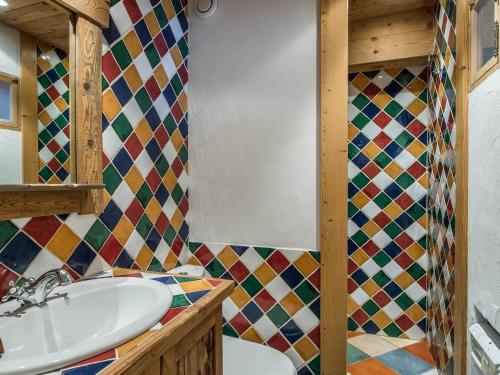 La salle de bains est pourvue d'un lavabo et d'un mur carrelé. dans l'établissement Appartement rénové avec cuisine ouverte, balcon et accès direct aux pistes - FR-1-563-19, à Courchevel