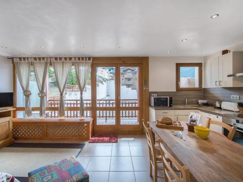 une cuisine avec une table et une grande fenêtre dans l'établissement Appartement rénové, ski au pied, en plein centre de Courchevel Moriond - FR-1-563-59, à Courchevel