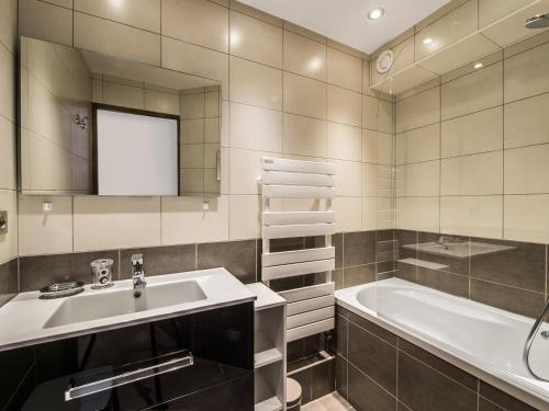 une salle de bain avec un lavabo et une baignoire dans l'établissement Appartement rénové, ski au pied, en plein centre de Courchevel Moriond - FR-1-563-59, à Courchevel