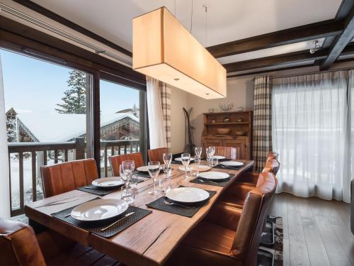 une salle à manger avec une longue table en bois et des chaises dans l'établissement Luxueux appartement 4 chambres avec parking au centre de Courchevel 1650 - FR-1-563-64, à Courchevel