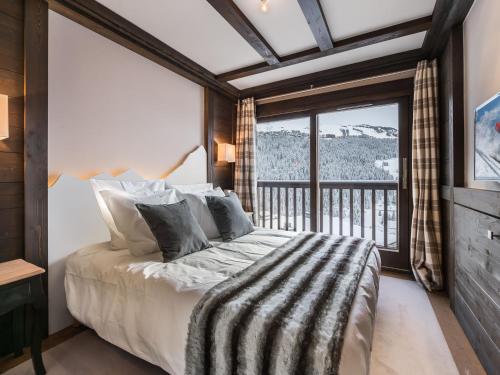 a bedroom with a large bed and a balcony at Splendide appartement centre Courchevel, 4 chambres, parking inclus - FR-1-563-64 in Courchevel