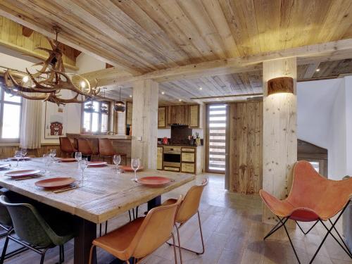 une salle à manger avec une grande table et des chaises en bois dans l'établissement Chalet élégant 4* à Méribel, proche télécabine Olympe, 4 chambres, dortoir, hammam et cheminée - FR-1-566-32, à Les Allues