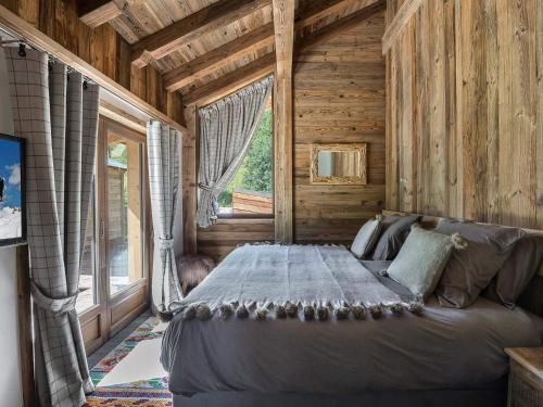 une chambre avec un lit dans une cabane en rondins dans l'établissement Chalet élégant 4* à Méribel, proche télécabine Olympe, 4 chambres, dortoir, hammam et cheminée - FR-1-566-32, à Les Allues