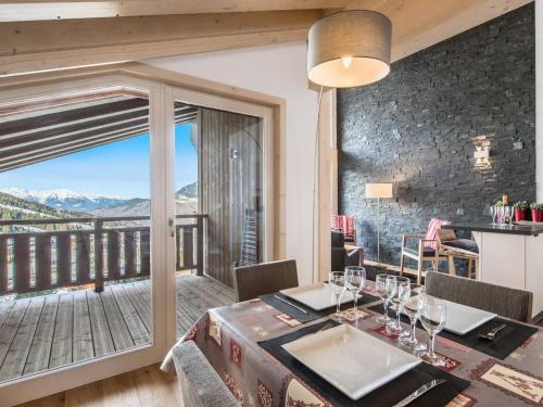une salle à manger avec une table et un balcon dans l'établissement Magnifique Penthouse T5 avec balcons dans Courchevel, Parking et WIFI inclus - FR-1-563-29, à Courchevel