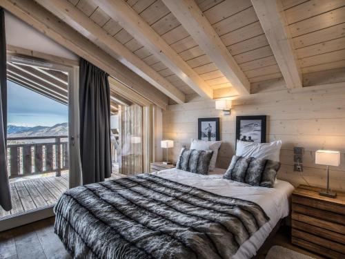 une chambre avec un grand lit et une grande fenêtre dans l'établissement Magnifique Penthouse T5 avec balcons dans Courchevel, Parking et WIFI inclus - FR-1-563-29, à Courchevel
