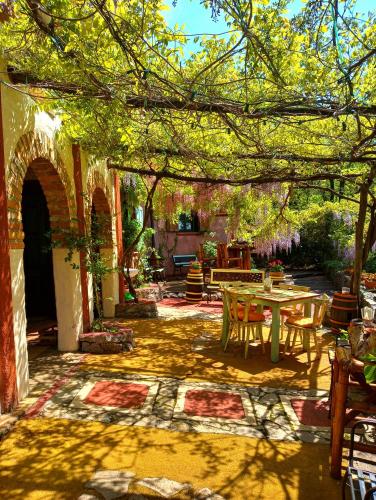 a patio with a table and chairs under a tree at Krasberry Ježev brlog in Komen