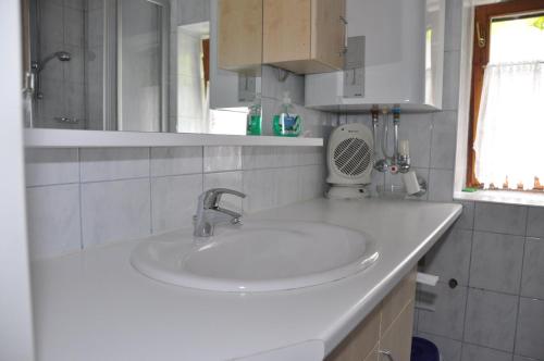 a white bathroom with a sink and a window at Ferienhaus Ackerl in Mitterretzbach