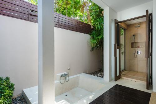 baño con bañera y ducha con ventana en Bacaya Beachfront Villa, en Bangrak Beach
