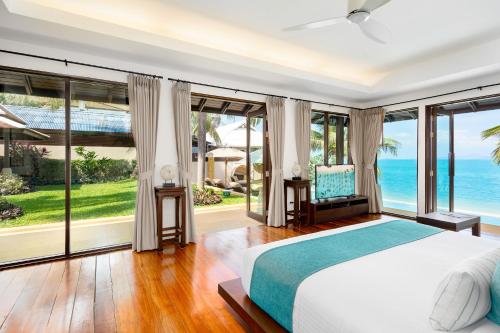 a bedroom with a bed and a view of the ocean at Bacaya Beachfront Villa in Bang Rak Beach