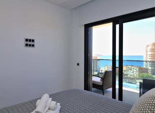 a bedroom with a bed and a view of the ocean at Sunset Drive Resort Apartment 5-10 Poniente Beach in Benidorm