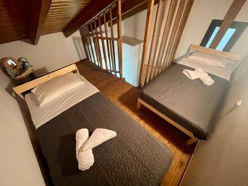 2 Betten in einem kleinen Zimmer mit weißen Handtüchern in der Unterkunft THE AA VILLA: Your Interactive Home Experience! in Kastamonítsa