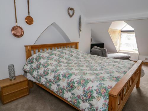 a bedroom with a bed with a floral bedspread at 4 Tanyrallt Terrace in Llangollen