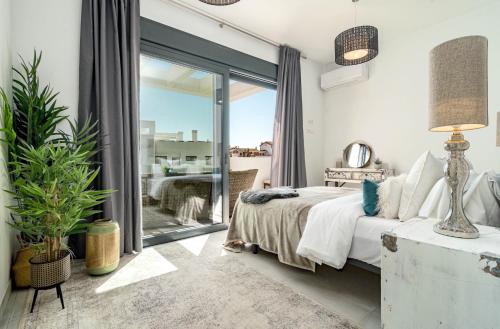 een slaapkamer met een bed en een glazen schuifdeur bij CDG- Cortijos Del Golf by Roomservices in Estepona
