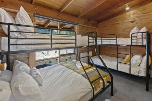 מיטה או מיטות קומותיים בחדר ב-AALFOR LODGE - Luxury Cabin with Spa & Cinema!