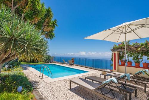 een zwembad met 2 stoelen en een parasol bij OurMadeira - Quinta D'Alegria, character in Funchal