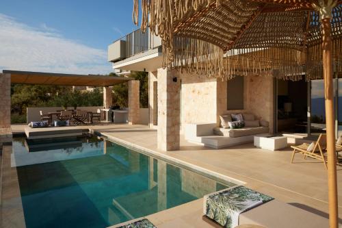 a villa with a swimming pool and a resort at Epiphany Villas Lefkada in Tsoukaladhes