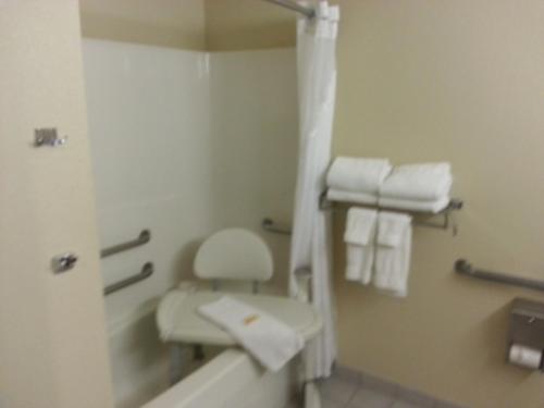 a bathroom with a toilet and a shower with towels at Country Inn & Suites by Radisson, Sidney, NE in Sidney