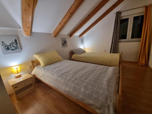 - une chambre avec 2 lits et une lampe sur une table de chevet dans l'établissement Apartman Delnice Park Srna, à Delnice