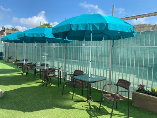 a group of tables and chairs with blue umbrellas at Vila Eric in Eforie Sud